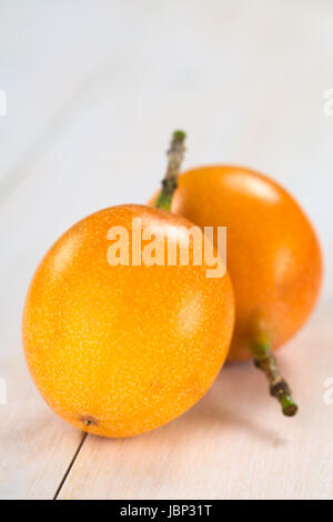 Süße Granadilla oder Grenadia (lat. Passiflora Ligularis) Obst, von denen die Samen und die umliegenden saftiges Fruchtfleisch wird gegessen oder wird verwendet, um Saft zu bereiten (selektiven Fokus, Fokus auf die Granadilla auf der Vorderseite) Stockfoto