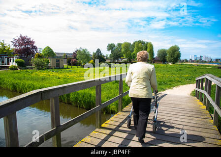 ältere Frau zu Fuß mit Hilfe bei Fußweg in den Niederlanden Stockfoto