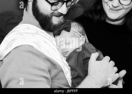 Neuen Vater Tochter zu halten, während sie, während Mama Uhren schläft Stockfoto