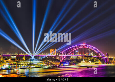 Bunte Beleuchtung der Sydney Harbour Bridge und Übersee Passagierterminal um Circular Quay und The Rocks bei Vivid Sydney-Licht-Show und Stockfoto