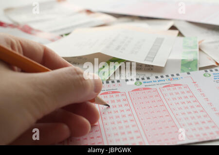Nahaufnahme einer Person Nummer auf Lottoschein mit Lottery Ticket Hintergrund markieren Stockfoto