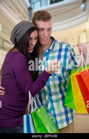 Ein Junges Pärchen suchen Etwas Beim Einkaufen in Einer Shopping-Mall Stockfoto