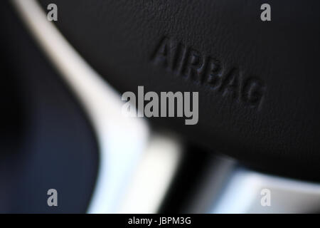 Das Wort "Airbag" ist auf ein Auto Lenkrad geschrieben. Stockfoto