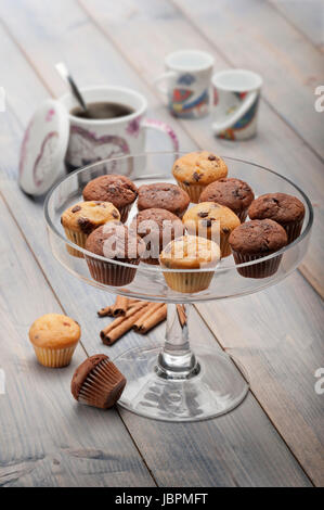 Tablett mit wenig Muffins Abwechslung auf Holztisch mit Tasse Kaffee Stockfoto