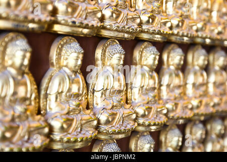 Zehntausend goldenen Buddhas aufgereiht entlang der Mauer des chinesischen Tempel in Thailand. Stockfoto