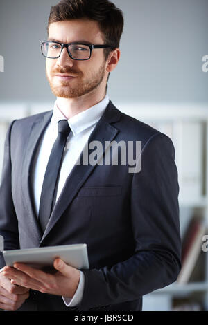 Gut aussehend Geschäftsmann mit Touchpad Blick in die Kamera Stockfoto