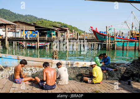 Eine Gruppe von Fischer Flicken ihre Netze an einem Pier auf Pangkor Island (Pulau Pangkor), Malaysia. Stockfoto