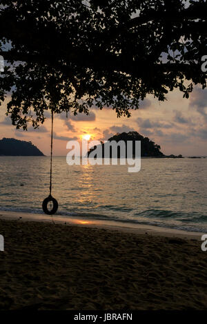 Ein Reifen schwingen bei Sonnenuntergang am Strand Teluk Nipah, Pangkor Island (Pulau Pangkor), Malaysia. Stockfoto
