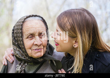 Bild einer schönen jungen Frau küssen ihrer kranken Großmutter Stockfoto