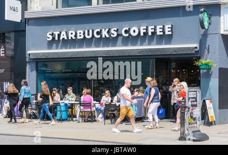 Starbucks Coffee-Shop. Leute sitzen draußen ein Starbucks Coffee Shop im Sommer in Brighton, East Sussex, England, UK. Stockfoto