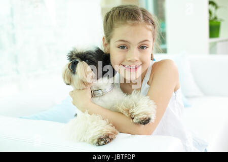 Porträt von glücklichen Mädchen halten Shih-Tzu Hund und Blick in die Kamera Stockfoto