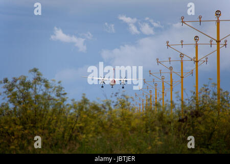 Qantas Bombardier Dash 8 landet auf dem Flughafen von Sydney, nähert sich über grün (Fenchel) und Flughafen-Blitzleuchten Stockfoto