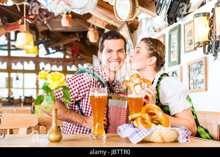 Bayerischen Mann spielt Volksmusik für Frau trägt dirndl Stockfoto