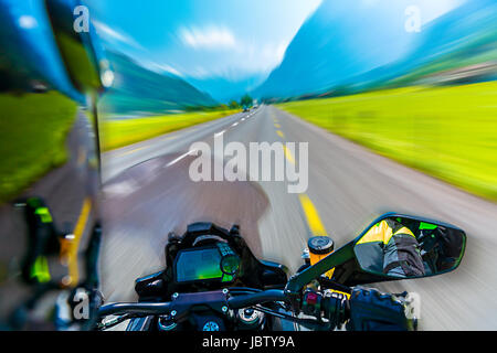 Slow-Motion von Motorrad fahren auf der bergigen Autobahn, Extremsport, Touren entlang der Alpen, Sommerabenteuer, Speed-Konzept Stockfoto