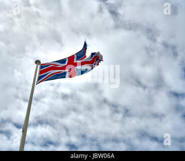 Eine leicht zerrissene Union Jack-Flagge, die im Wind flackelt Stockfoto