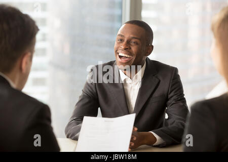 Glücklich schwarzen erfolgreiche Kandidaten immer gemietet, fröhliche afrikanische Antragsteller mit strahlenden Lächeln bekam einen Traumjob in großen Unternehmen, dunkel-enthäuteten Geschäftsmann Stockfoto