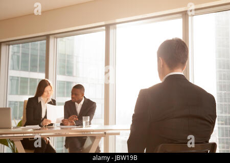 Nervösen Bewerber sitzen auf Stuhl warten auf Ergebnis nach Vorstellungsgespräch, besorgt Geschäftsmann erwartet für genehmigen Entscheidung während der Expertengruppe c ablehnen Stockfoto