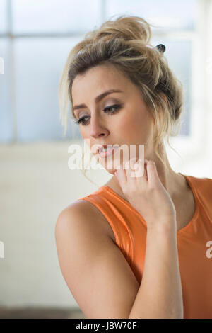 Schöne junge Frau Hand berühren Gesicht wegschauen Stockfoto