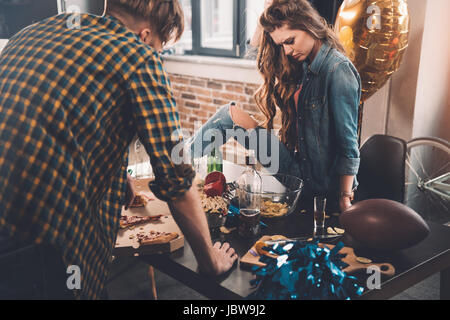 Mann und Frau Reinigung unordentlichen Zimmer nach party Stockfoto