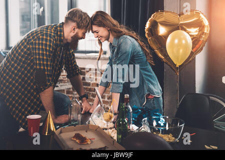 Mann und Frau Reinigung unordentlichen Zimmer nach party Stockfoto