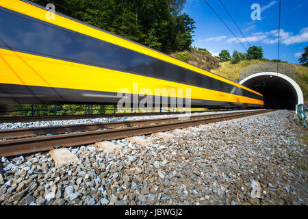 Schnellzug auf der Durchreise eines Tunnels an einem schönen Sommertag (Bewegung verschwommenes Bild) Stockfoto