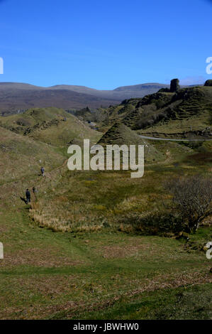 Zwei Personen in der Nähe von Rocky Turmburg Ewen & Kegel geformt Hügelchen in Fairy Glen in der Nähe von Uig, Isle Of Skye, North West schottischen Highlands wandern, Stockfoto