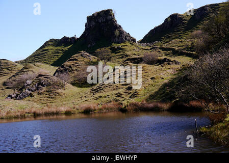 Zwei Personen in der Nähe von Rocky Turmburg Ewen & Kegel geformt Hügelchen in Fairy Glen, Uig, Isle Of Skye, North West schottischen Highlands, Schottland. Stockfoto