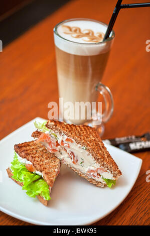 Sandwich mit Käse und Lachs und Gemüse mit latte Stockfoto