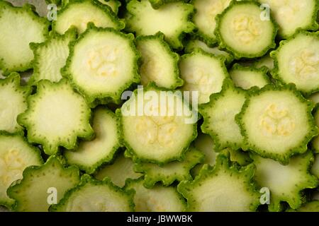 grüne Zucchini in Scheiben geschnitten Hintergrund. Sommerkürbis Scheiben Stockfoto