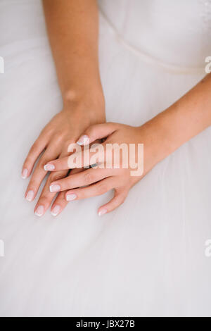 Fine Art Hochzeit. Porträt einer jungen schönen Braut in weißer Spitze Hochzeitskleid und Schleier legte anmutig Hand zusammen. Stockfoto