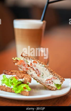 Sandwich mit Käse und Lachs und Gemüse mit latte Stockfoto