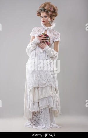 Eleganz. Wunderschöne Mode-Modell in langes Kleid und Blumenstrauß Stockfoto