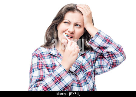 Unzufriedene Frau ihre Zähneputzen am Morgen im Schlafanzug auf weißem Hintergrund Stockfoto