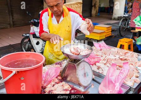 GEORGE TOWN, MALAYSIA - März 23: Metzger verkauft Hühnerfleisch auf dem nassen Markt von George Town, Penang, Malaysia. am 23. März 2016 in George Town, Mal Stockfoto