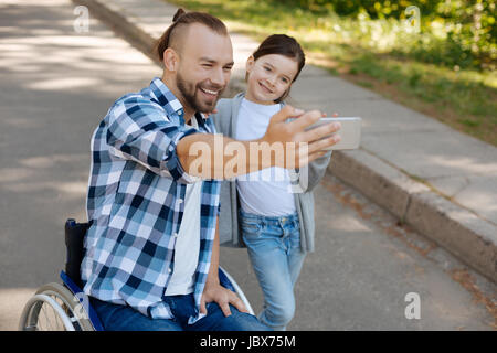 Hübsches Mädchen nehmen Foto am Telefon mit ihrem Vater Stockfoto