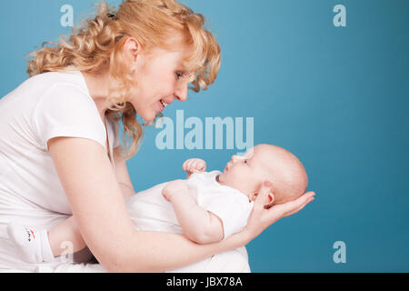 Mama schaut liebevoll Baby Sohn hält auf Seite Stockfoto