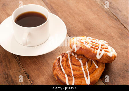 Tasse frisch gebrühten voll Braten Filter oder Espresso Kaffee mit flockig fruchtigen dänisches Gebäck beträufelt mit Puderzucker für einen leckeren Kaffee-Pause Stockfoto