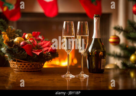 Nahaufnahme Bild von zwei Gläsern Champagner auf Weihnachten Tisch nächsten brennenden Kamin Stockfoto