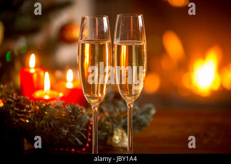 Nahaufnahme Bild von zwei Gläser Champagner vor Weihnachtskranz und Kamin Stockfoto