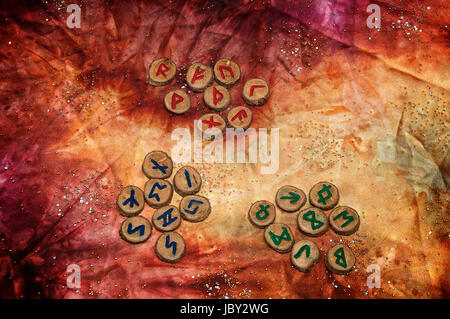 drei Sätze von Holz Runen, einem alten Alphabet das Futhark genannt sind auf eine bunte Hand gefärbtes Gewebe mit kleinen funkelnden Perlen. Hinweis: Diese Runen wurden von den Fotografen gemacht. Stockfoto