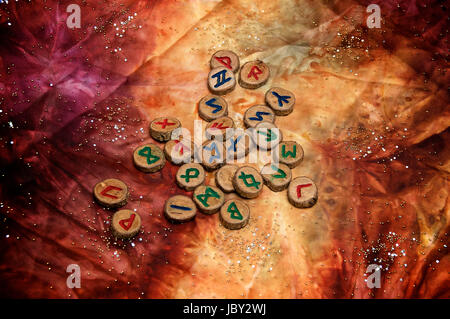 Hand geschnitzten und bemalte hölzernen Runen, eine antike Alphabet das Futhark genannt sind auf eine bunte Hand Stoff mit kleinen funkelnden Perlen gefärbt. Hinweis: Diese Runen wurden von den Fotografen gemacht. Stockfoto