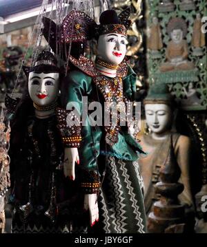 Zwei reich verzierte handgemachte traditionelle burmesische Marionetten mit aufgemalten weißen Gesichtern hängen in einem Souvenirladen in Myanmar Stockfoto
