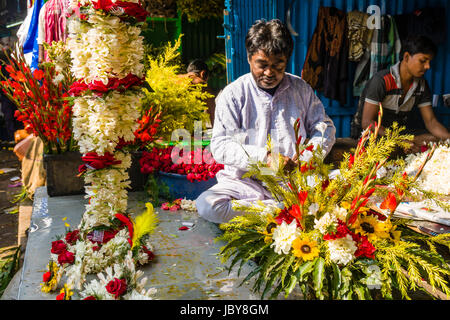 Blumenarrangements sind produziert und von Herstellern, die in der täglichen Blumenmarkt unter Howrah Bridge verkauft Stockfoto