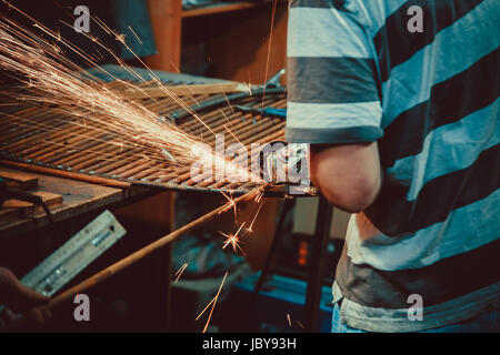 Funken, die beim Schneiden von Metall Winkelschleifer. Close-up Säge Sägen a Stahl. Soft Focus. Flache Freiheitsgrad. Stockfoto