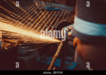 Funken, die beim Schneiden von Metall Winkelschleifer. Close-up Säge Sägen a Stahl. Soft Focus. Flache Freiheitsgrad. Stockfoto