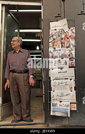 Der Besitzer eines langjährigen Buchhandlung im Hamra Viertel von Beirut steht in der Tür Rauchen einer Zigarette während der Nachbarschaft beobachten. Stockfoto