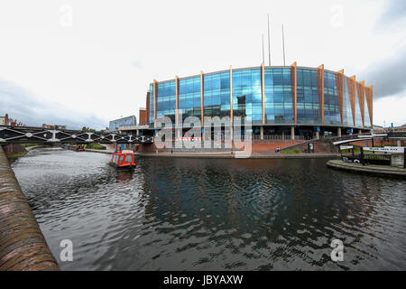 Birmingham, Großbritannien. 12 Juni, 2017. Die National Indoor Arena von Brindley Place, Kanal im Vordergrund, mit Kahn vorbei Stockfoto