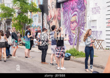 Tausende Gießen in Bushwick, Brooklyn in New York für die jährliche Bushwick kollektive Block Party auf Samstag, 3. Juni 2017. Musik und Party brachte einige, aber die eigentliche Attraktion war die neue Wandmalereien von "" Graffitikünstler, die die Wände der Gebäude schmücken, die das Kollektiv verwendet.  (© Richard B. Levine) Stockfoto