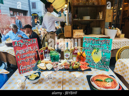 Ein Tisch voller Essen und Getränke, die im Zusammenhang mit der Mailänder Tradition der "Aperitivo" in den Abendstunden Stockfoto