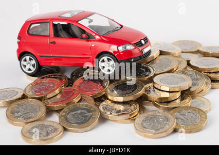 Kosten für Autofahren, Reparaturen, Steuer, TÜV und Versicherungen. Neue Pfund-Münzen. Stockfoto